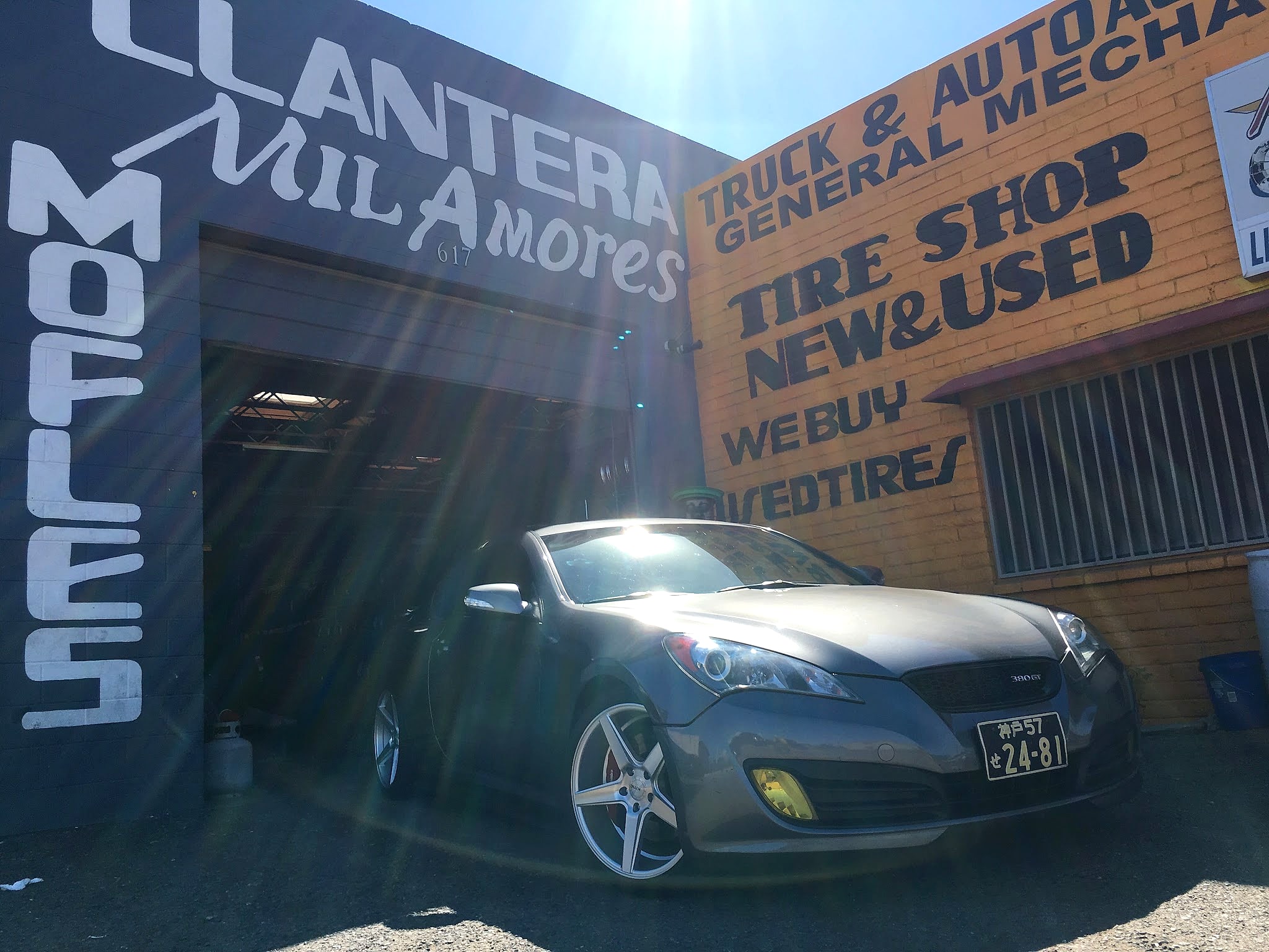 Gray coupe parked in front of the Llantera Mil Amores sign