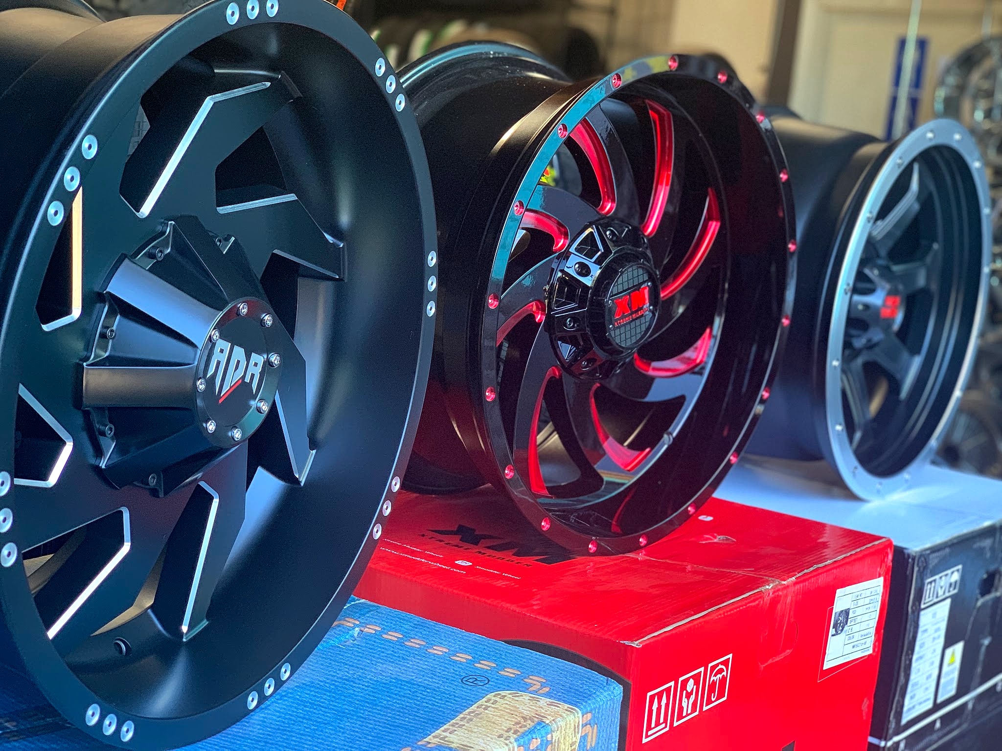 Black and red custom wheels lined up in the shop