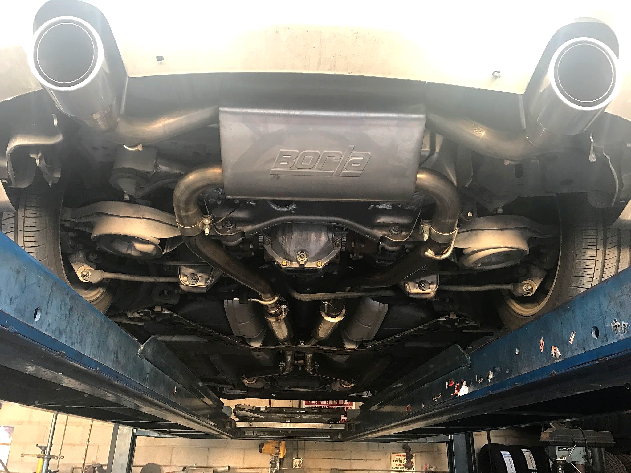 Underside of a car on the lift with a new exhaust system