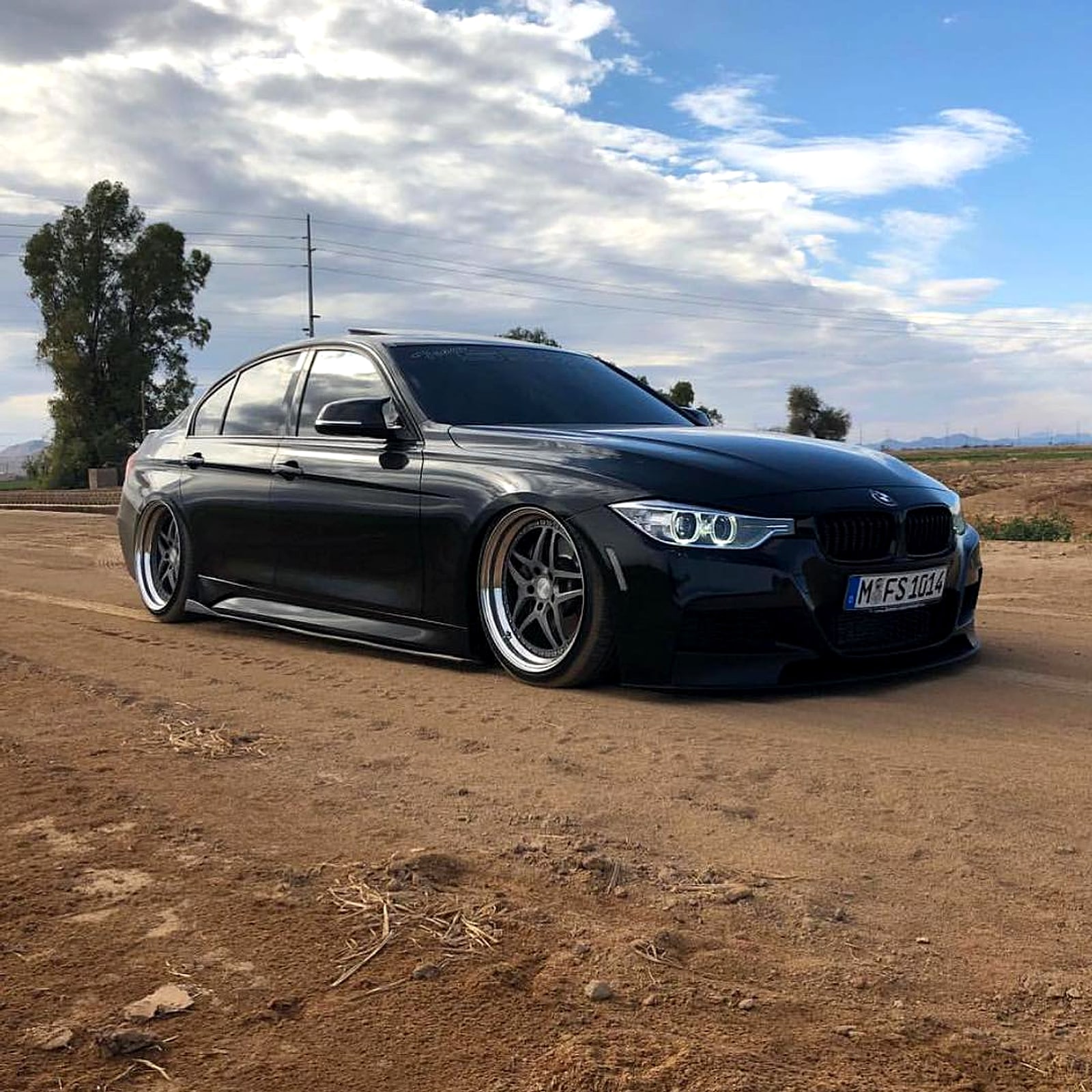 Black BMW sedan on new wheels in the desert